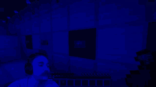 a man wearing headphones is playing minecraft