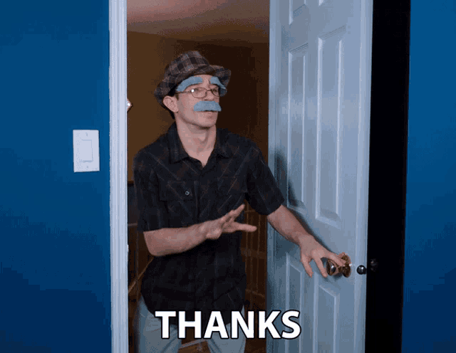 a man wearing a hat and glasses is standing in a doorway with the words thanks written on it