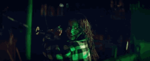 a bottle of alcohol is sitting on a table with green lights in the background .