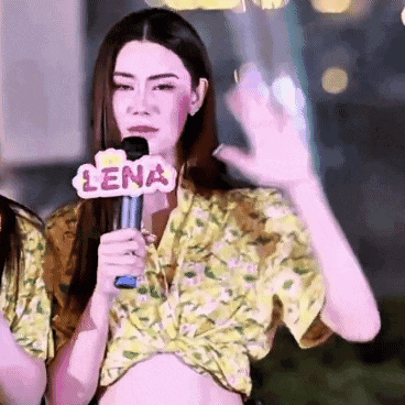 a woman holding a microphone with lena on it