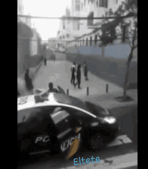 a police car is parked on the side of the road in front of a building .