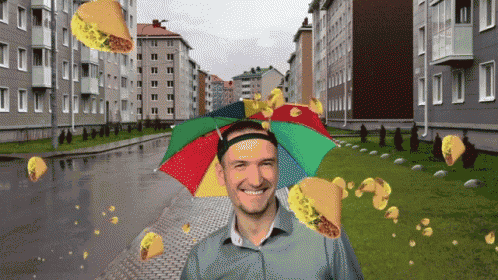 a man wearing a colorful umbrella hat with tacos coming out of it