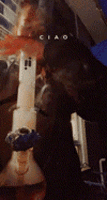 a blurry picture of a person smoking a bong with the word ciao on the bottom
