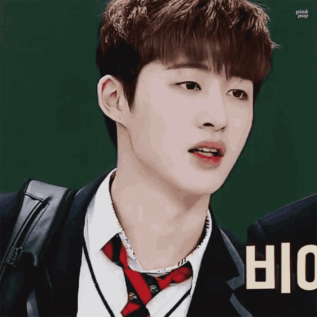 a close up of a person wearing a suit and tie with the letters biu in the corner