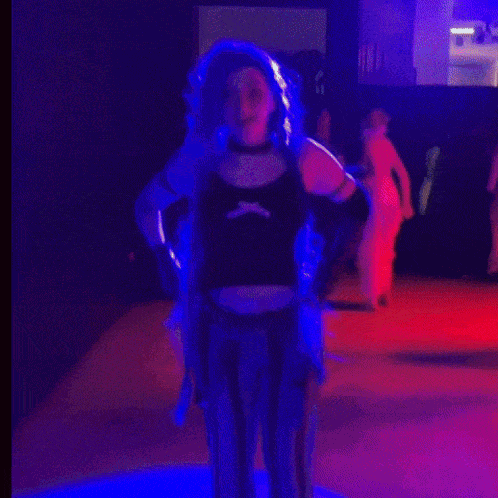 a woman in a pirate costume stands in a dark room with red lights