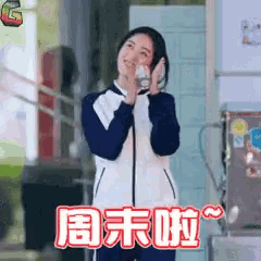 a woman is standing in front of a fridge with chinese writing on it
