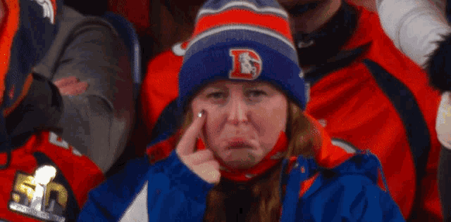 a woman wearing a beanie with a letter d on it