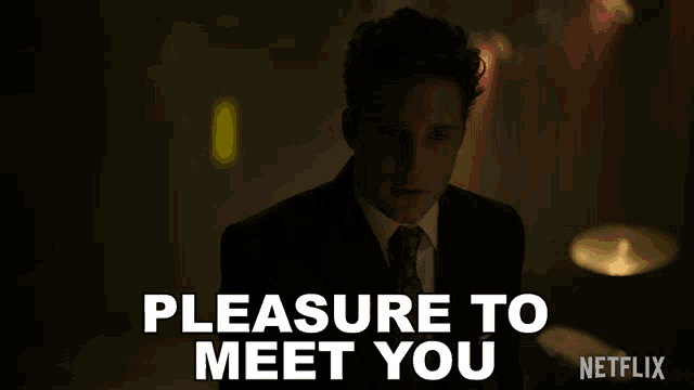 a man in a suit and tie says " pleasure to meet you " in white letters