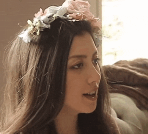 a woman wearing a headband with flowers in it