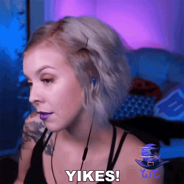 a woman wearing headphones says " yikes " in a video