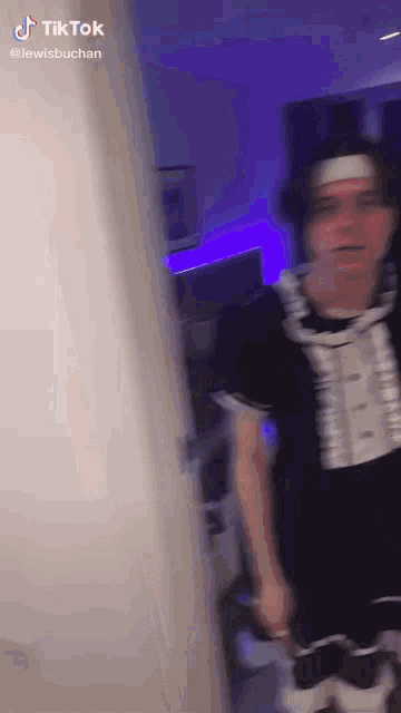 a man dressed as a maid is standing in a room .