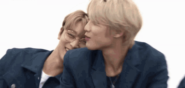 two young men are sitting next to each other and laughing .