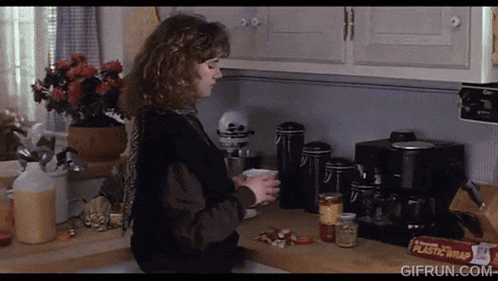 a woman in a kitchen with a box of plastic wrap in front of her
