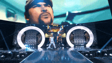 a man on a stage with a large screen behind him that says ' don 't tell '