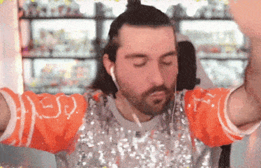a man with a beard wearing a sequined shirt with the letter r on it