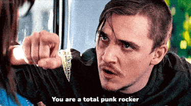 a man in a black shirt says you are a total punk rocker in front of a woman