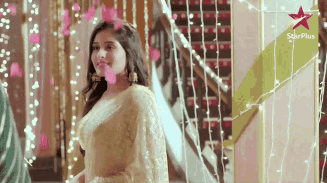 a woman is standing in front of a star plus banner