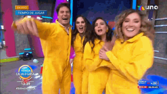 a group of people wearing yellow jumpsuits are on a tv show