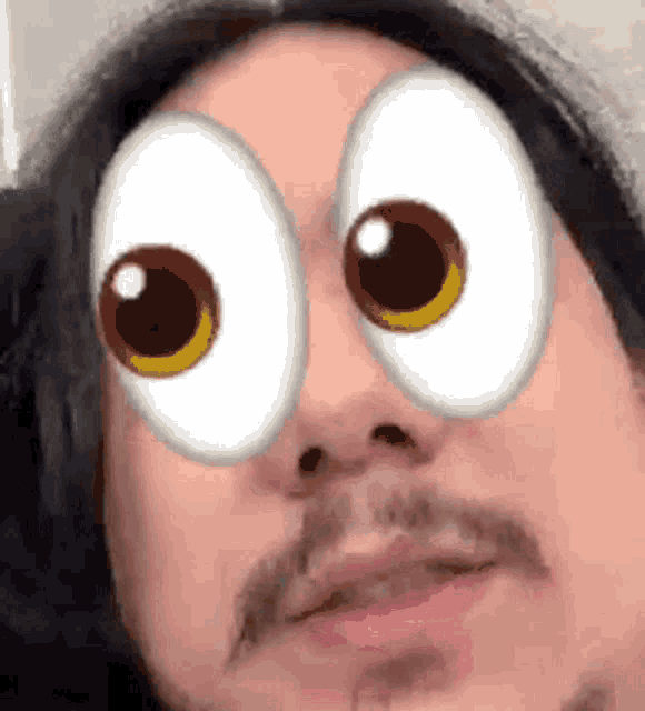 a man with long hair and a mustache is wearing a pair of cartoon eyes .