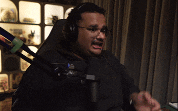 a man wearing headphones and glasses is sitting in front of a microphone
