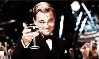 a man in a tuxedo is toasting with a glass of wine .