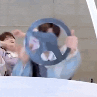 a person is holding a steering wheel in their hands and spinning it around .