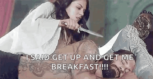 a woman is holding a knife over a man 's head while he sleeps .