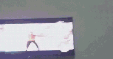 a man in a red shirt is dancing on a tv