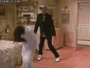 a man in a suit is dancing with a little girl in a bedroom with senorgif.com on the bottom right