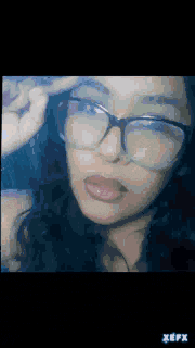 a close up of a woman wearing glasses with the word xefx on the bottom right