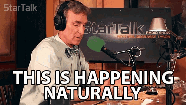 a man sitting in front of a microphone with the words " this is happening naturally " above him