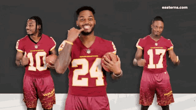 three washington redskins players are posing for a picture and one has the number 24 on his jersey