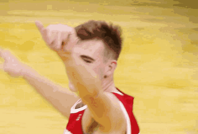 a basketball player wearing a red jersey that says brooklyn