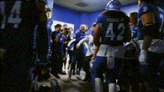 a football player with the number 42 on his back walks through a locker room