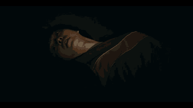 a person wearing a green and brown striped shirt is laying down