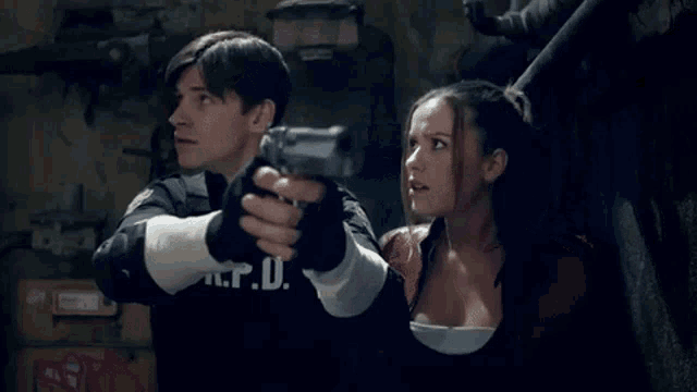 a man and a woman are standing next to each other holding guns in a dark room .