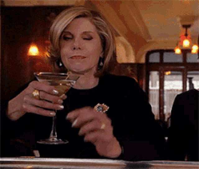 a woman is holding a martini in her hand