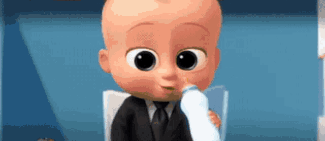 a baby in a suit is drinking milk from a bottle .