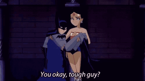 batman is carrying wonder woman in his arms and says " you okay , tough guy ? "