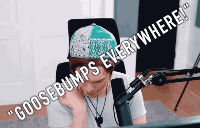 a man sitting in front of a microphone with the words " goosebumps everywhere " written above him