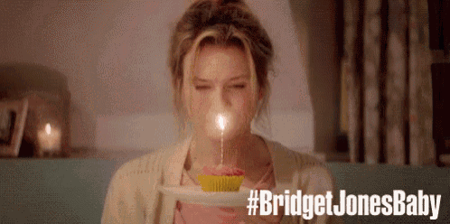 a woman is blowing out a candle on a cupcake with the words bridget jones baby below her