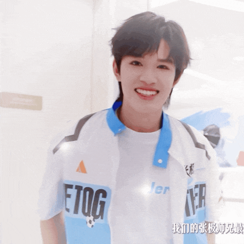 a young man wearing a white shirt with the word etog on it