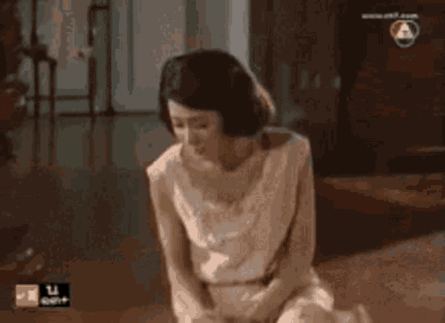 a woman in a white dress sits on the floor next to a dog ..