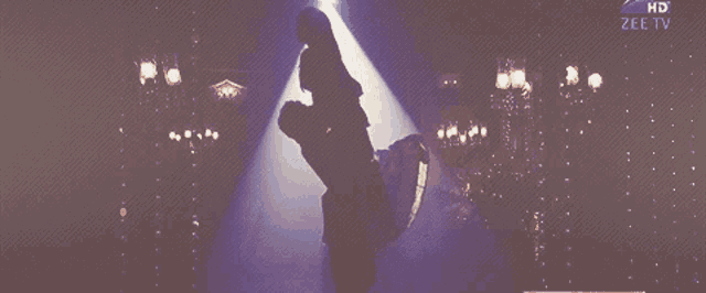 a silhouette of a woman in a spotlight with the words hd zee tv on the bottom right