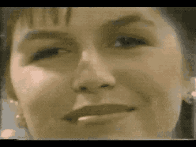 a close up of a woman 's face with earrings on