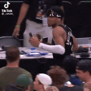 a basketball player is taking a picture of himself in a crowd .