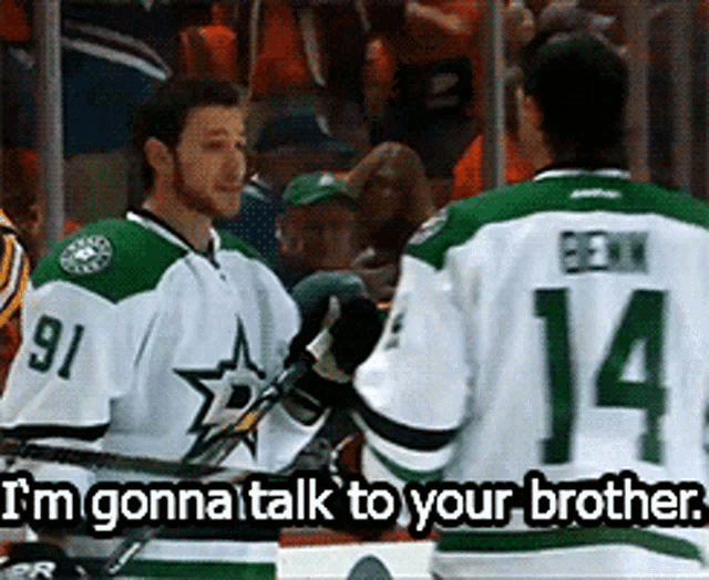 a hockey player with the number 14 on his jersey talks to another player