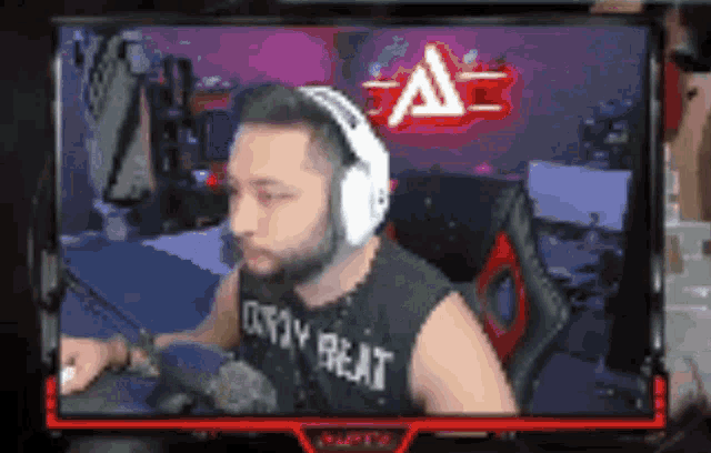 a man wearing headphones and a shirt that says defy beat is sitting in front of a computer screen