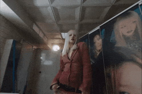 a woman with white hair and red lipstick is wearing a red jacket