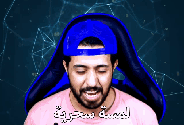 a man wearing a pink shirt and a blue hat with arabic writing